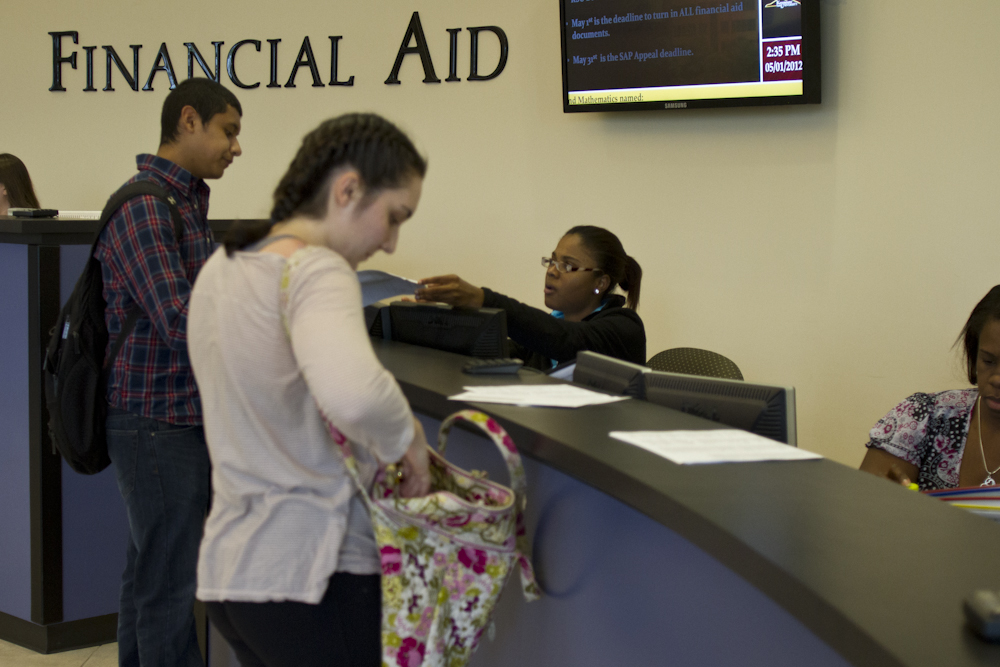 Kennesaw State University sophomore Dennys Rosales, 19, (left) checks with the Financial Aid Office to see if his summer tuition will still be covered by the Pell Grant.